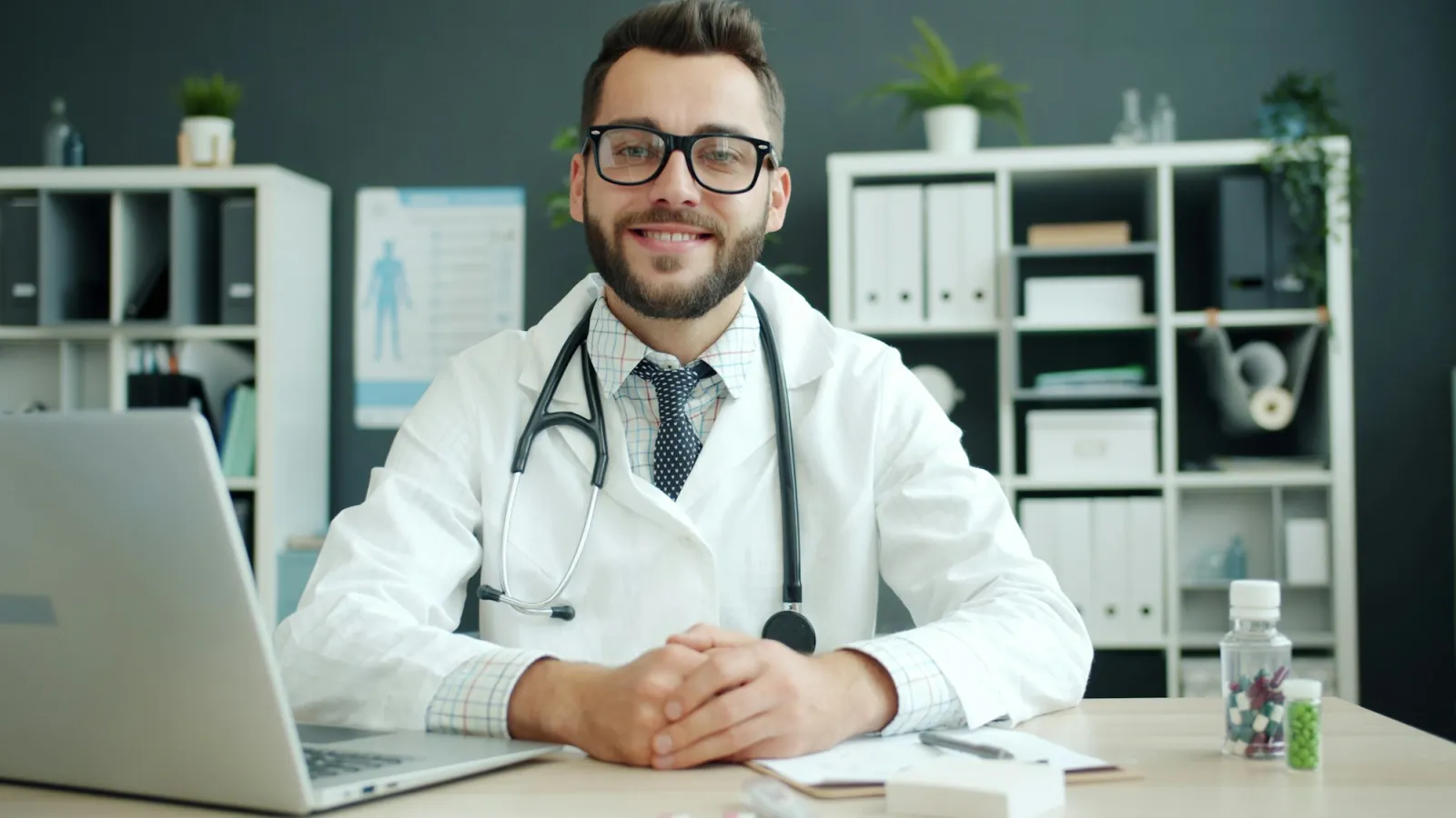 Médico en su escritorio, con la laptop abierta